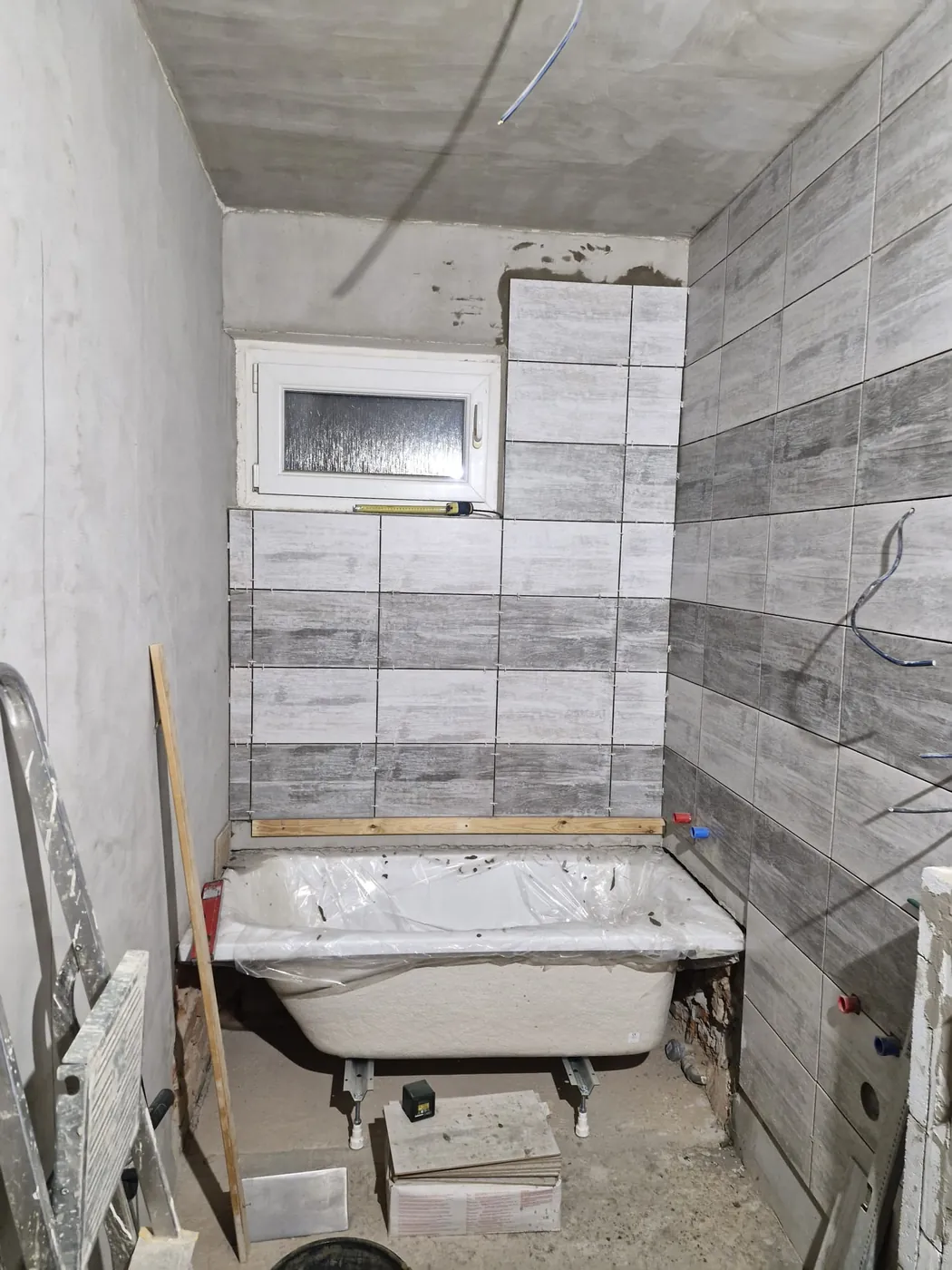 Usazená vana a dokončený obklad stěny